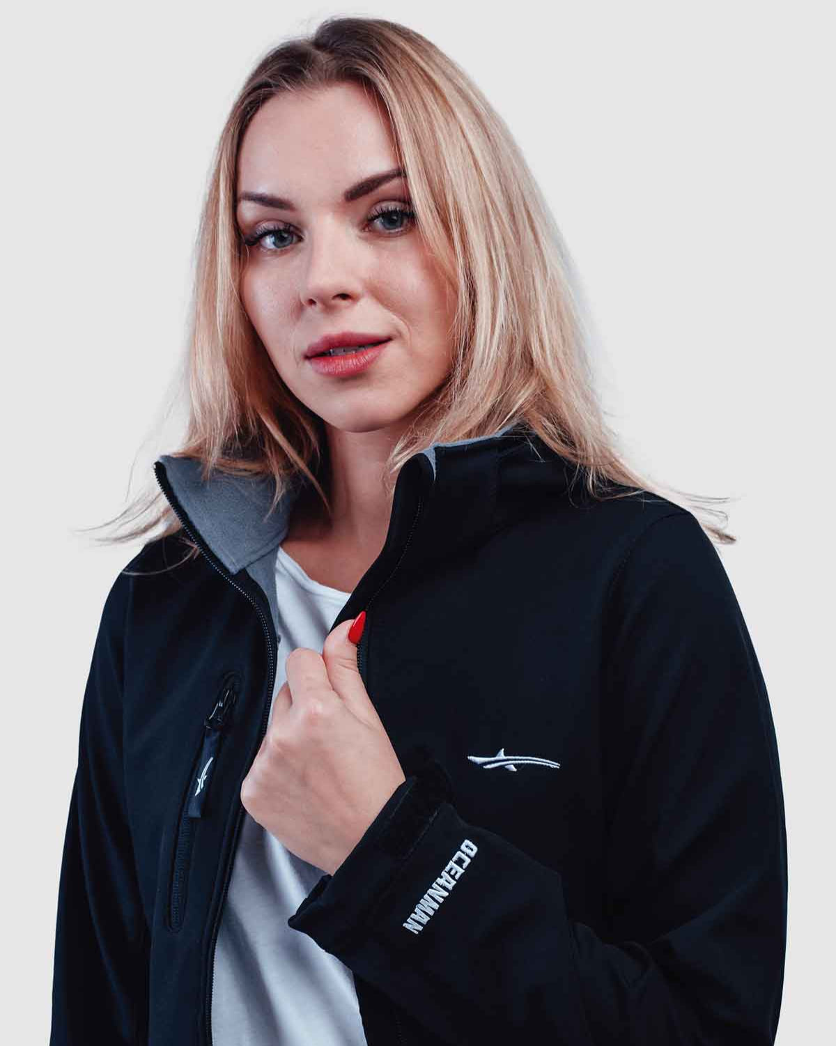 Woman wearing a black jacket with oceanman logo and details