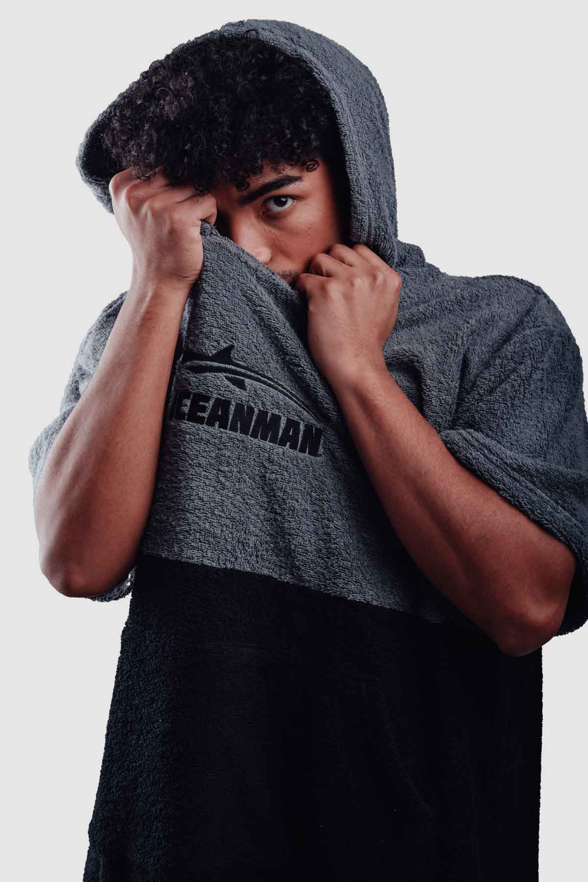 man wearring oceanman poncho and covering his face